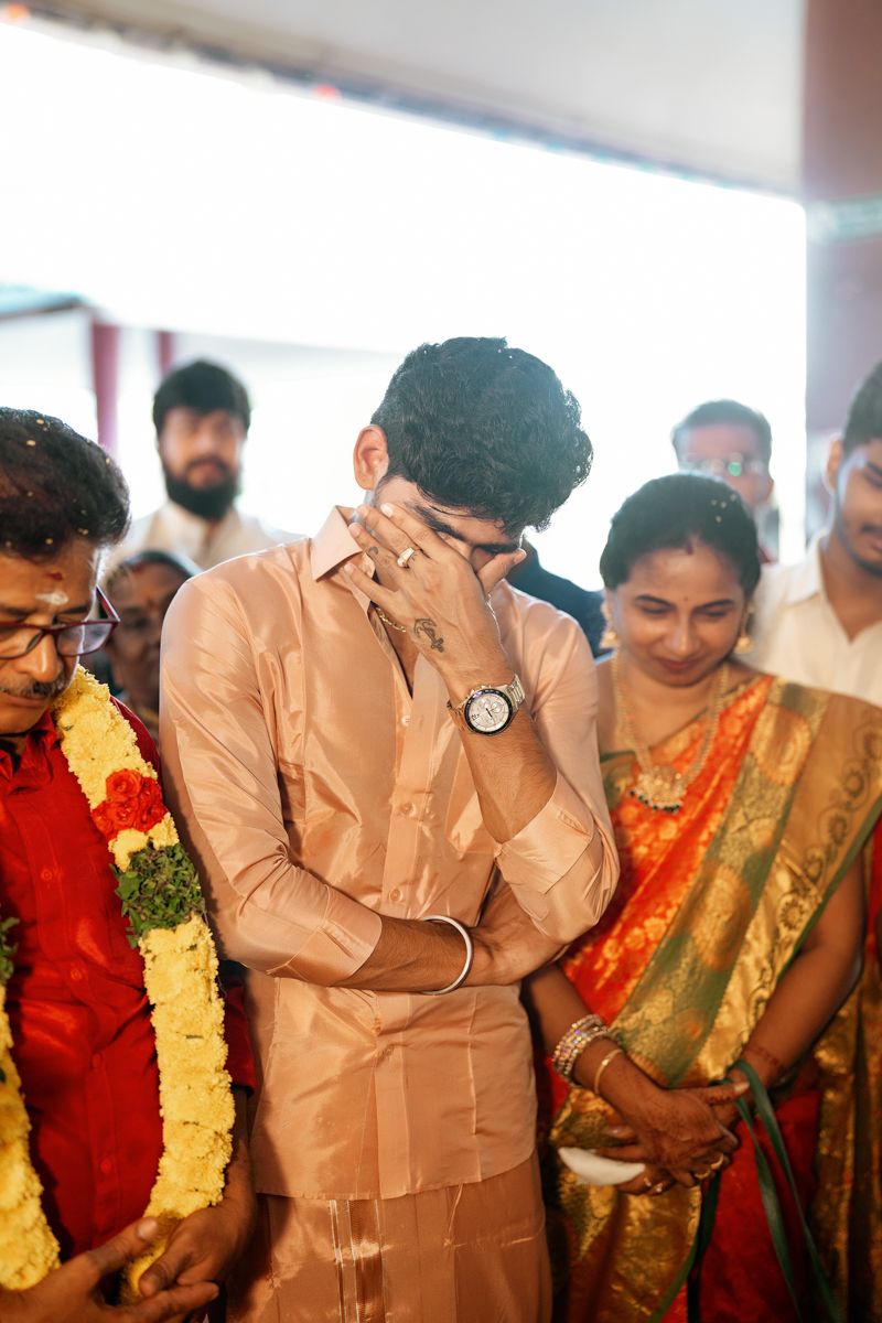 A group of guests at a traditional Indian wedding ceremony shows emotional reactions during a special moment.