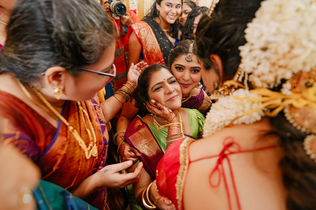 Group celebrating at an Indian wedding in vibrant traditional attire with joyful expressions.