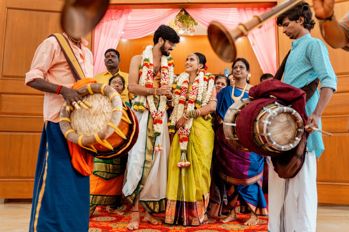Traditional Indian wedding ceremony with musicians playing drums and guests in colorful attire.