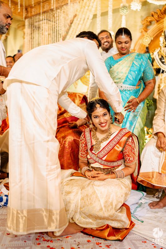 Traditional blessing ceremony during South Indian wedding with guests in colorful attire.