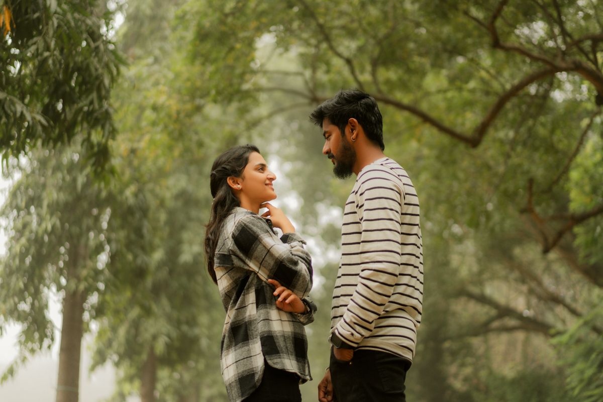 A misty forest setting provides a romantic backdrop for a couple sharing an intimate moment together.