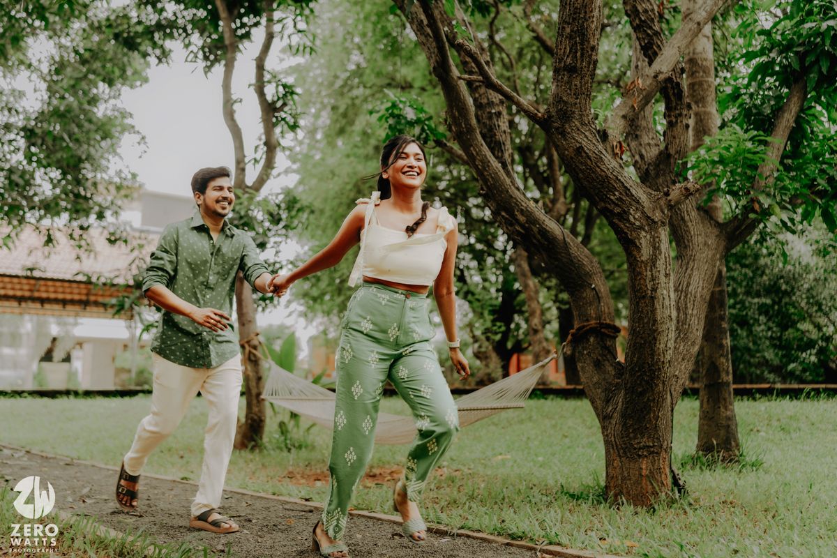 People enjoying a playful outdoor photoshoot amidst green trees and grass at a park.