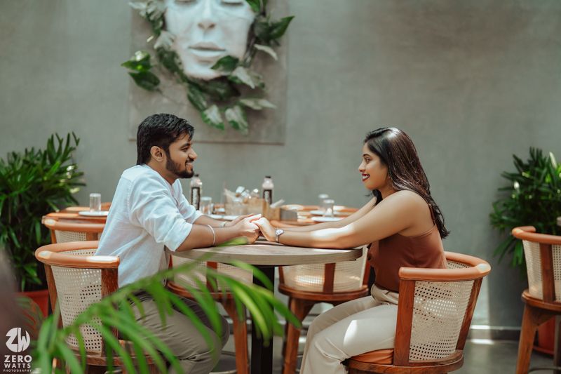 Romantic indoor setting with plants and cafe furniture for intimate photoshoot.