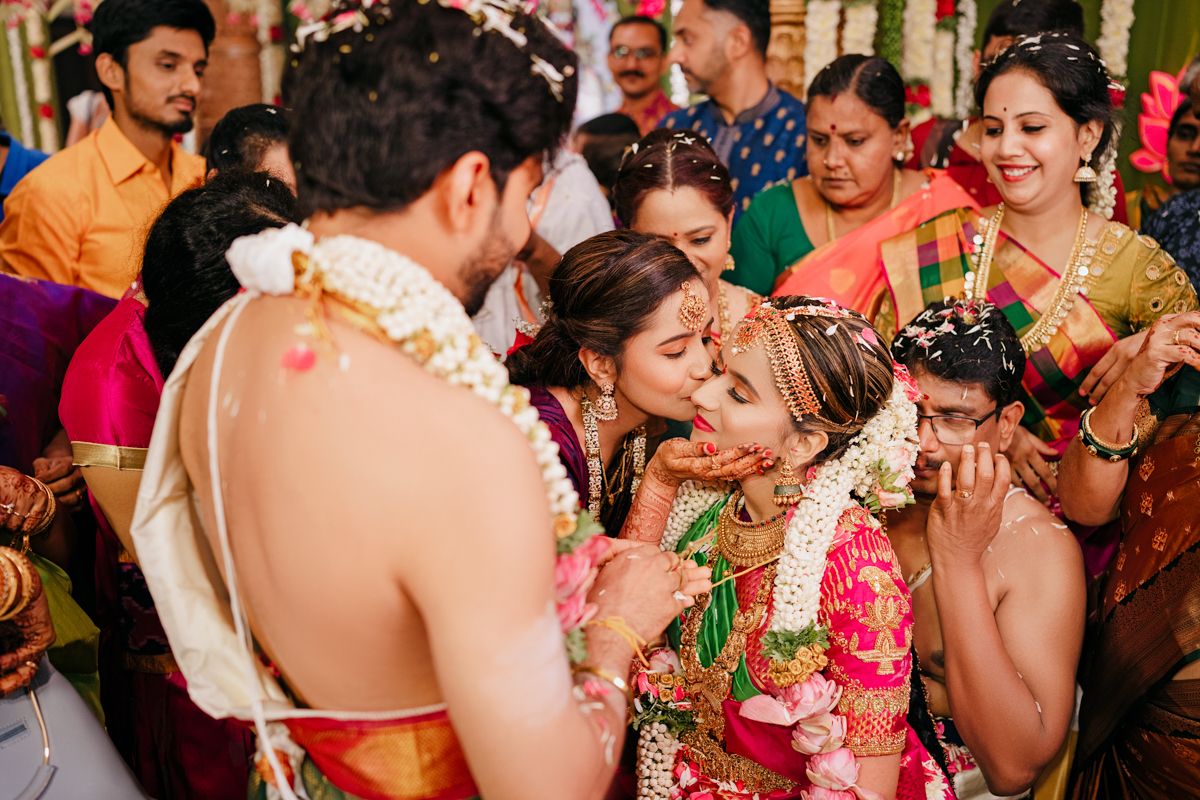 Wedding guests gather around couple during traditional South Indian ceremony rituals.