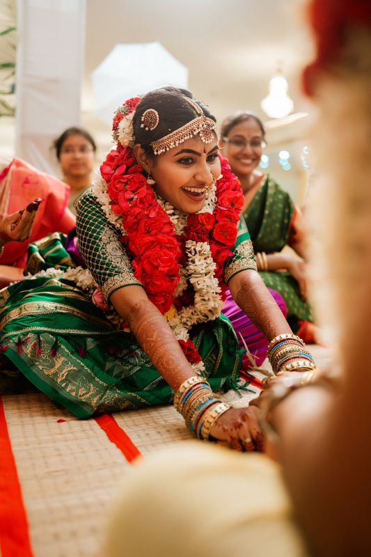 Traditional South Indian wedding ceremony with participants wearing colorful saris and floral garlands.