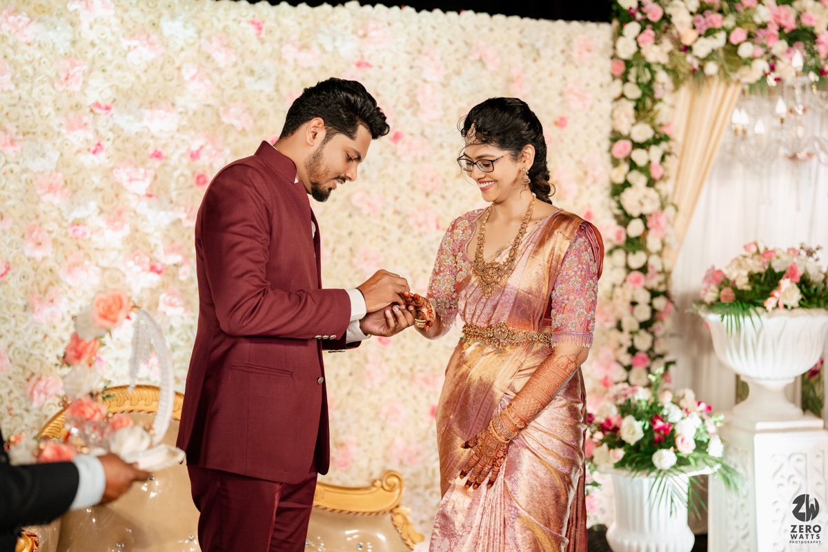 Elegant wedding ceremony setup with floral decor and pink flower wall backdrop for a romantic celebration.