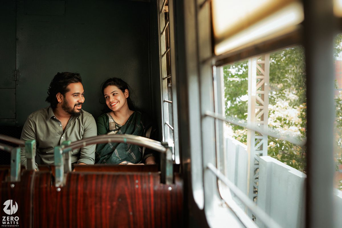 An intimate train car photoshoot showing tender moments by a window with warm natural lighting.