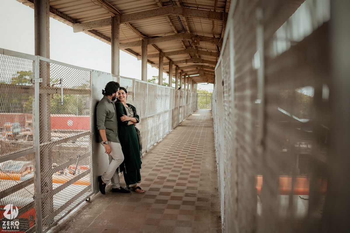 Two people standing close together in a covered railway platform walkway.