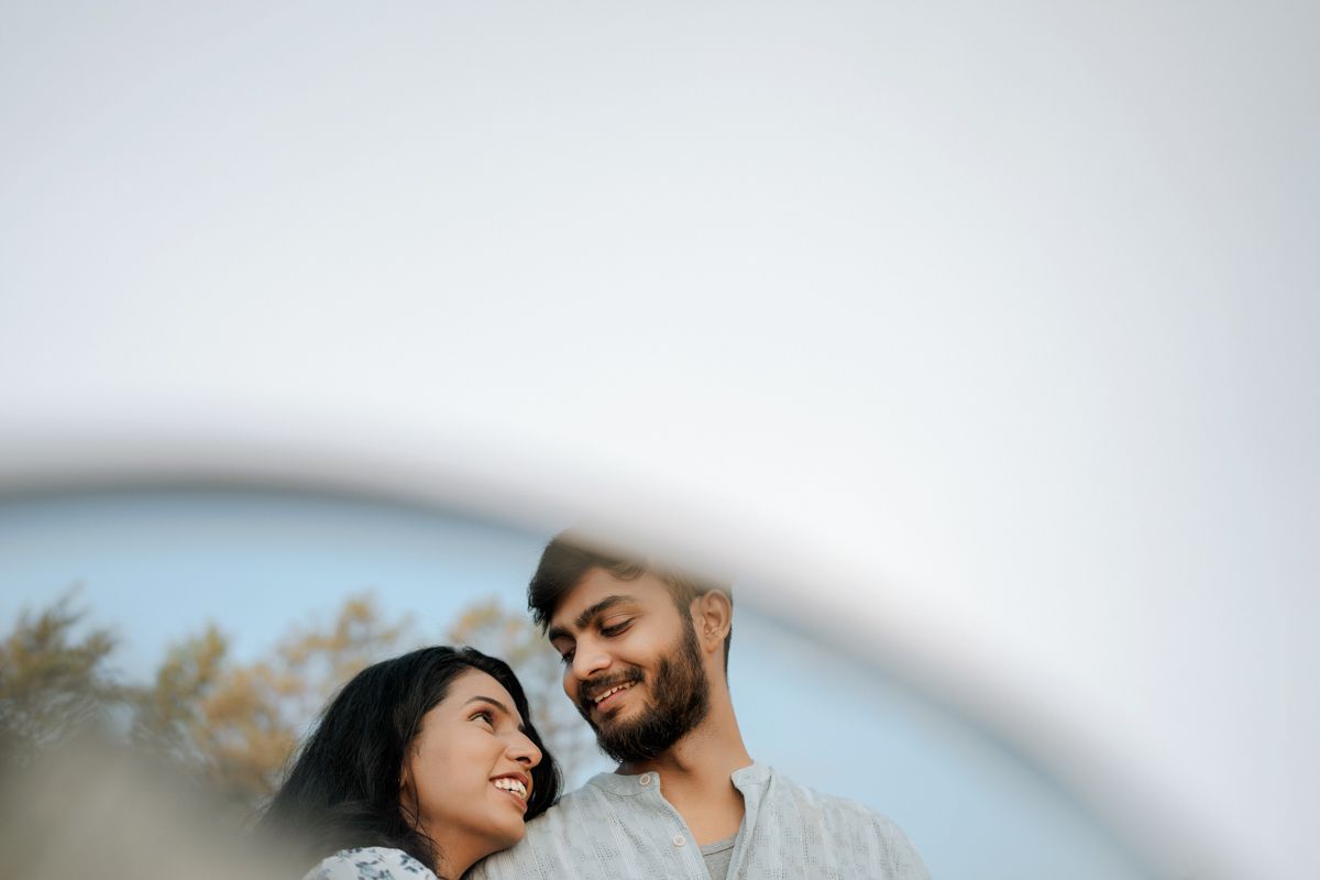 Joyful couple sharing an intimate moment outdoors with soft lighting and natural surroundings.