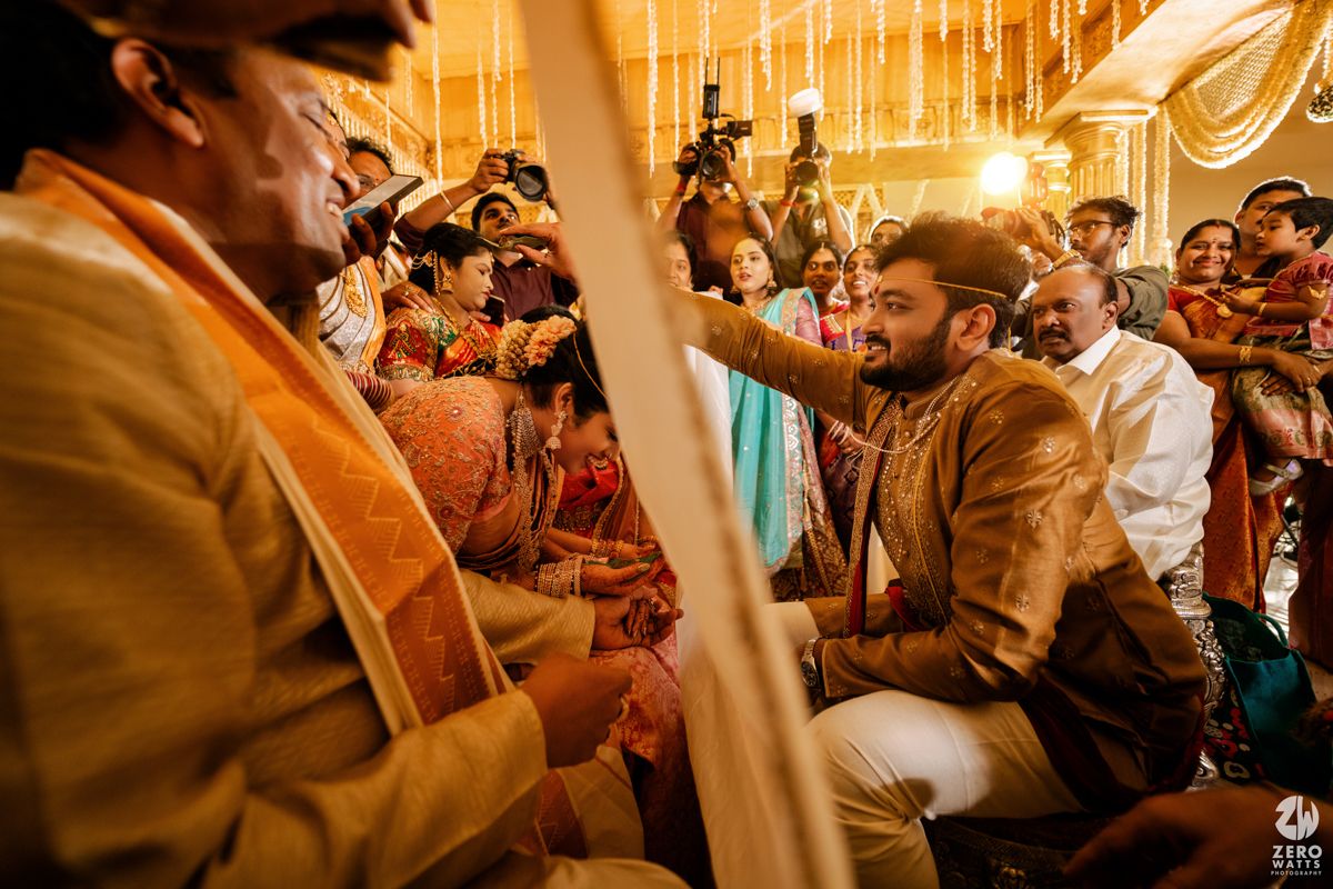Traditional wedding ceremony with warm lighting showing rituals being performed among decorated surroundings.