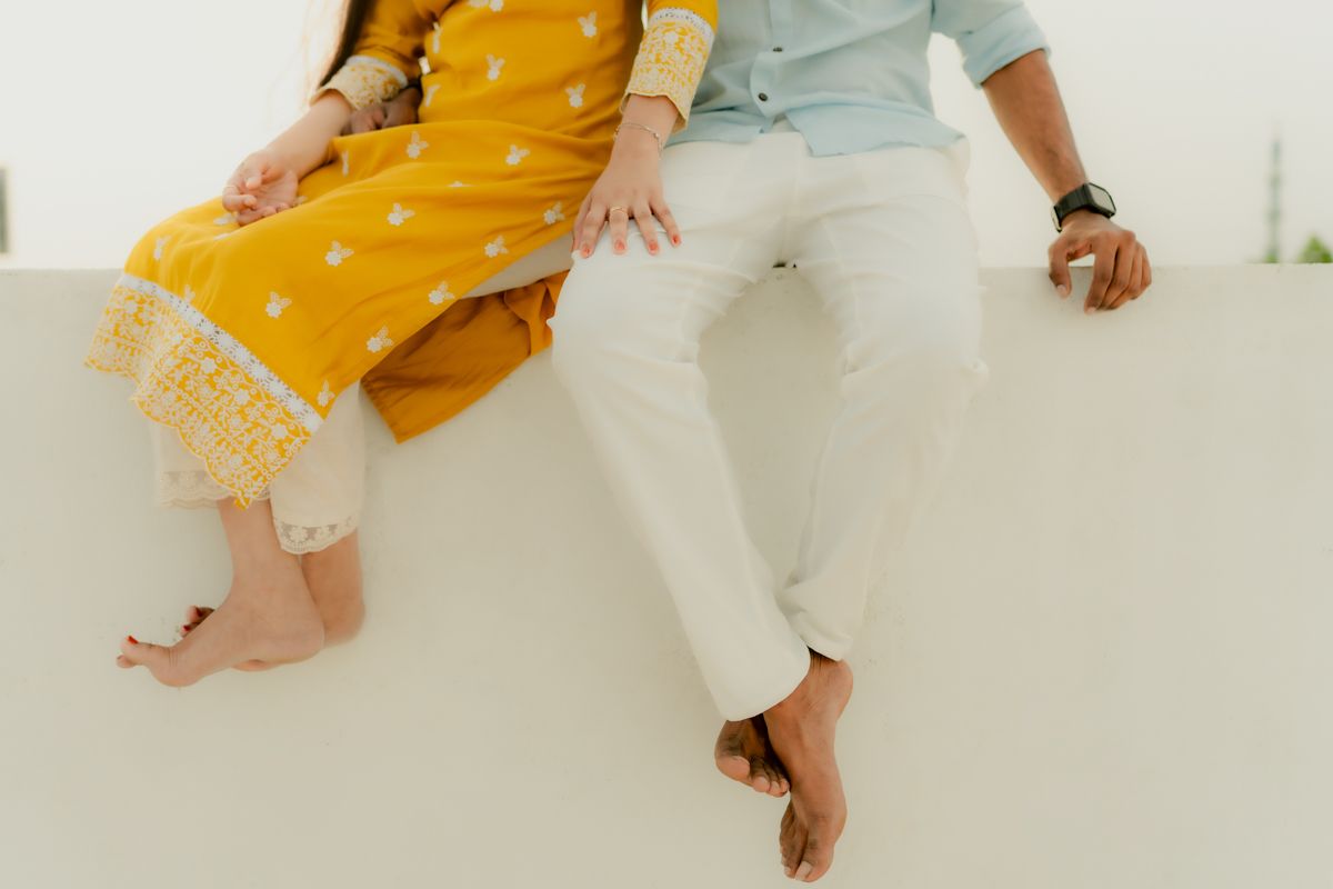 Close-up shot of two people sitting side by side showing their casual attire and bare feet.