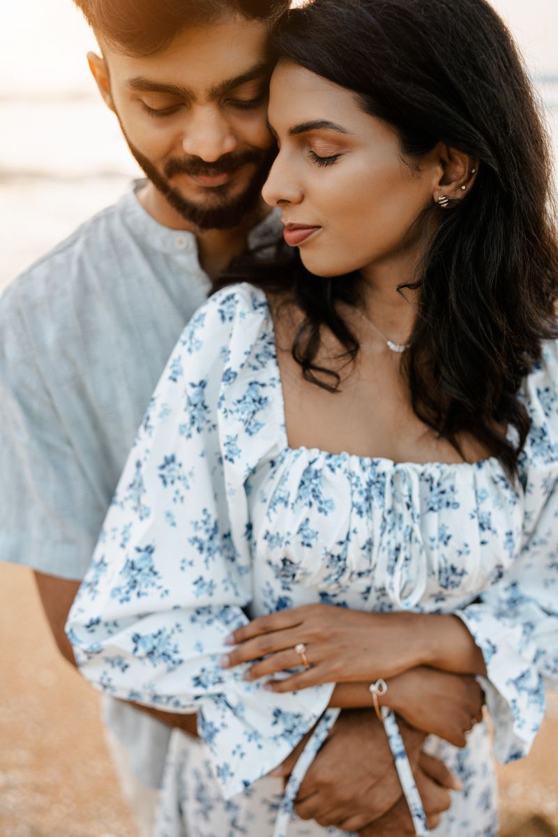 A couple in casual attire sharing an intimate moment during golden hour.