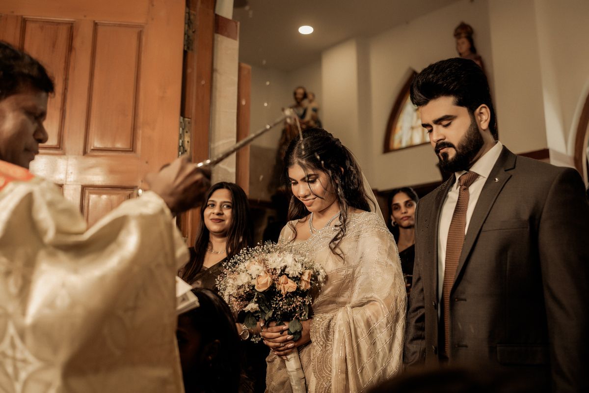 Traditional South Asian wedding ceremony captured in warm lighting with elegant decorations and floral bouquet.