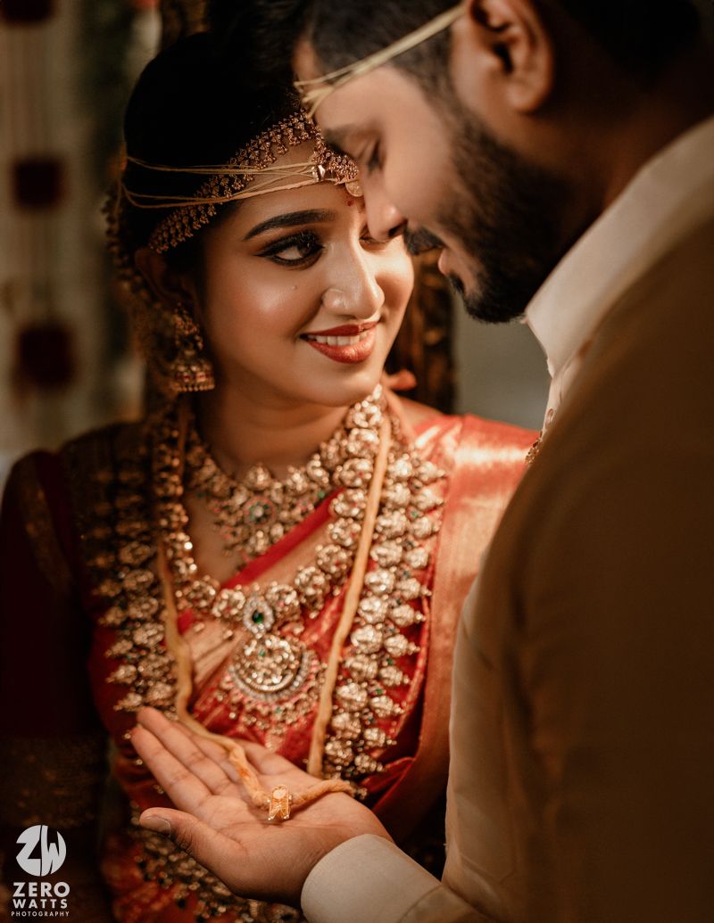 A close-up intimate moment captured during a traditional Indian wedding ceremony.