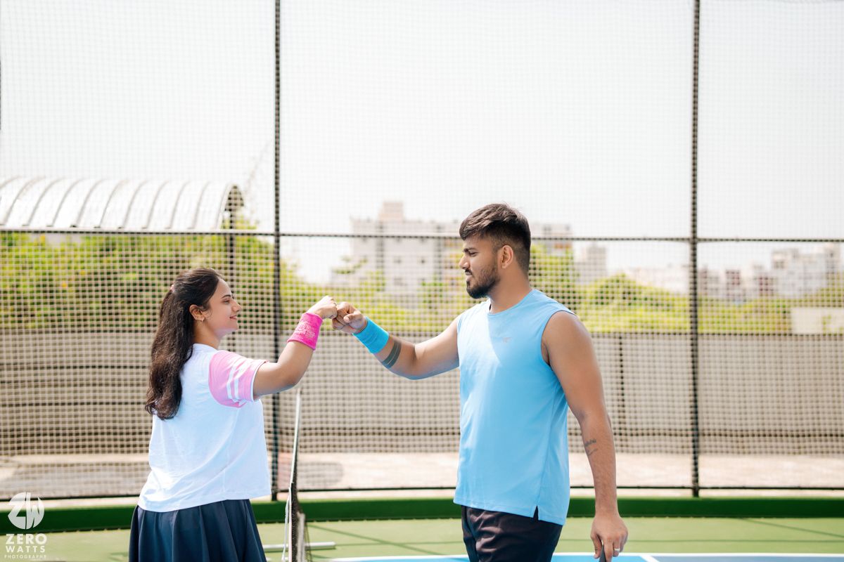 Players sharing a tender moment next to a tennis net on an outdoor court.