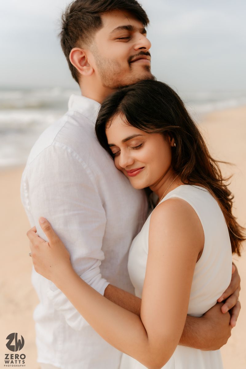 Close-up shots of tender embrace between couple in white outfits on sandy beach.