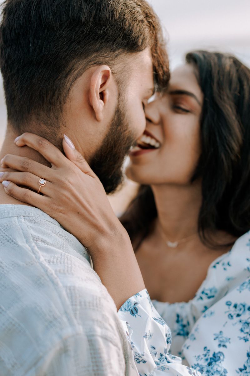 An intimate close-up of a couple sharing a romantic moment while wearing coordinated blue and white attire.