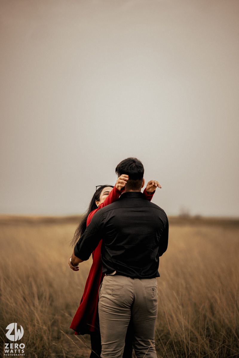 A romantic moment between two people embracing in a wheat field.