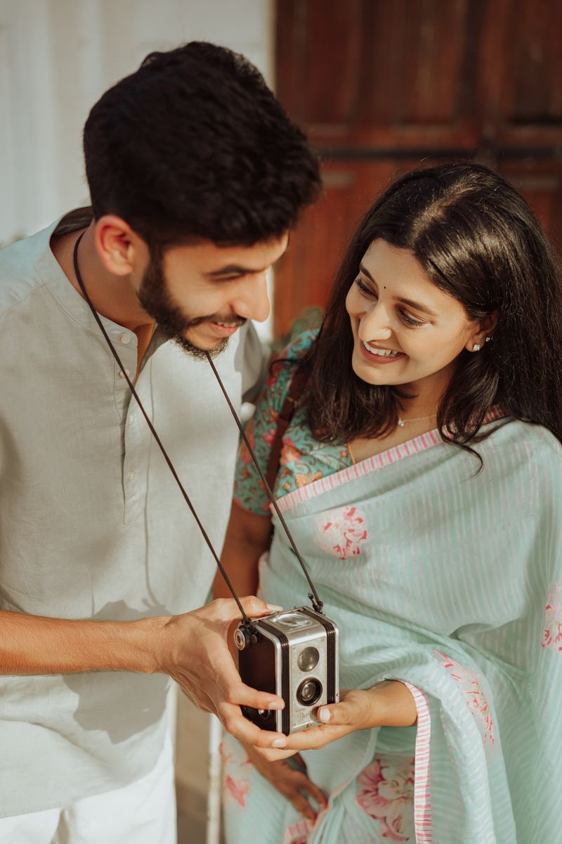 A vintage-themed photoshoot featuring a traditional saree and classic camera.