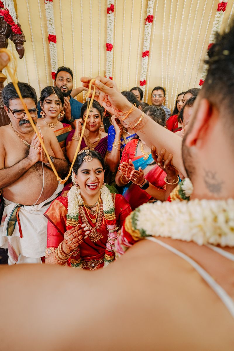 Traditional Hindu wedding ritual with guests gathered around during indoor ceremony.