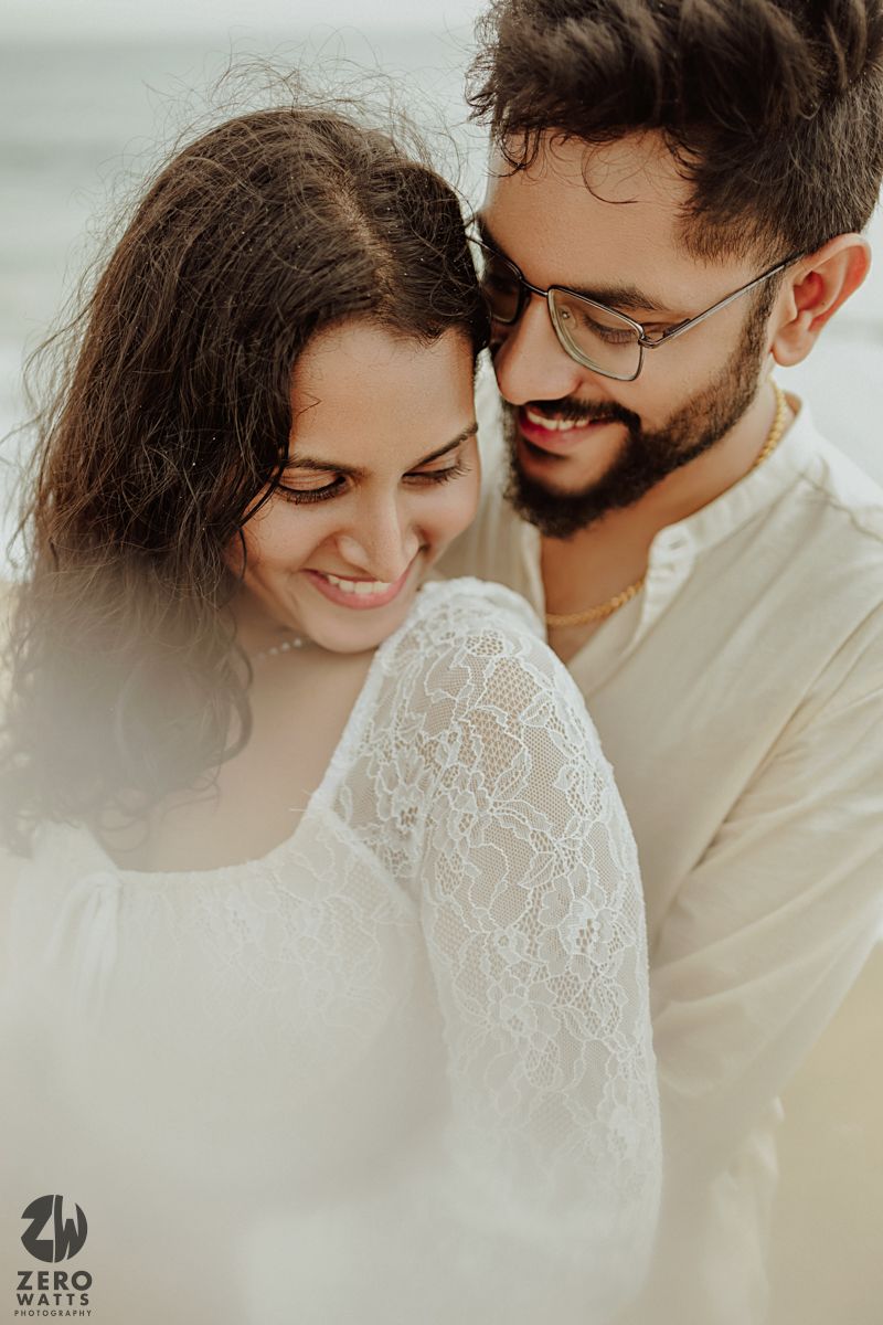 Intimate close-up portrait of couple in white outfits sharing tender moment.