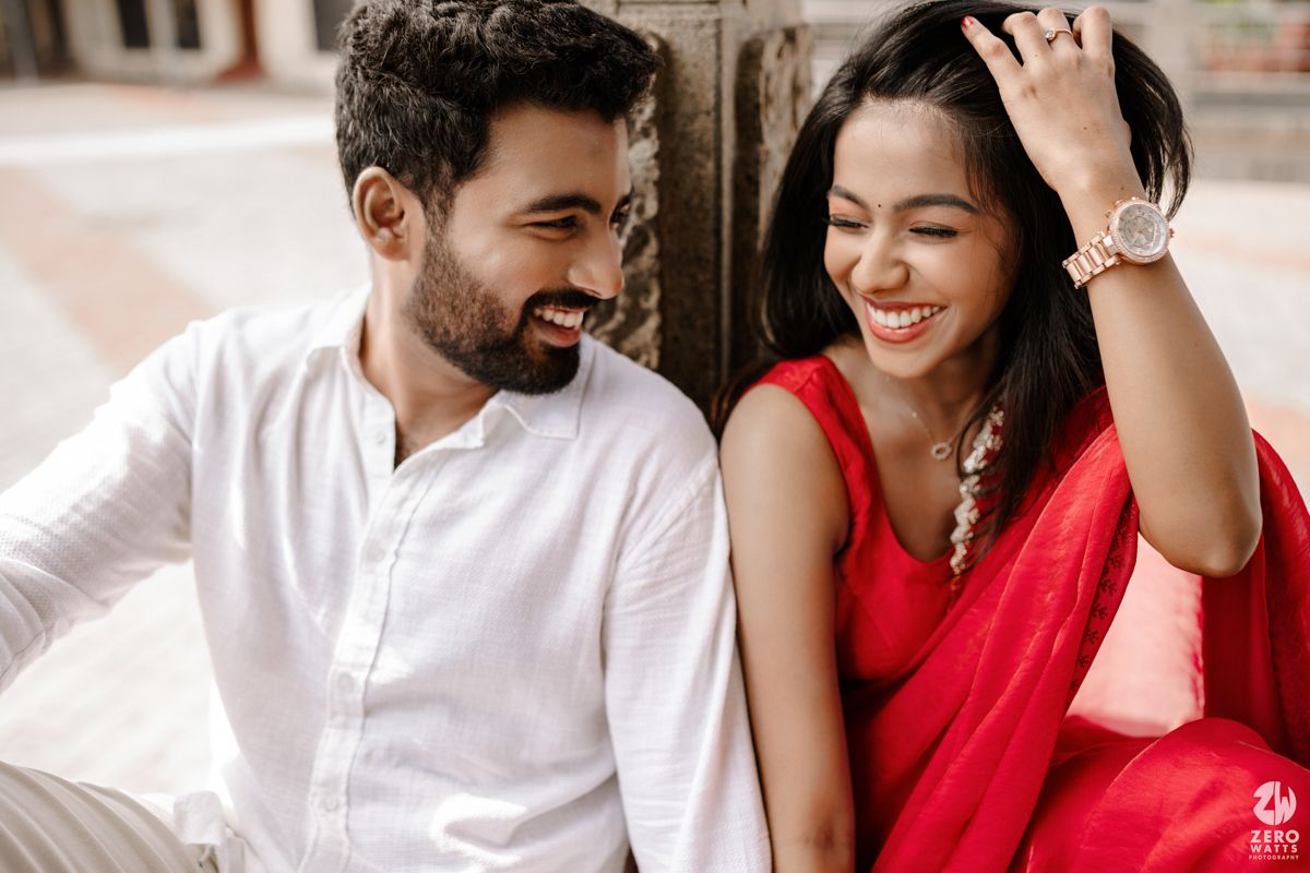 Romantic couple shares tender moments while sitting in a stone colonnade.
