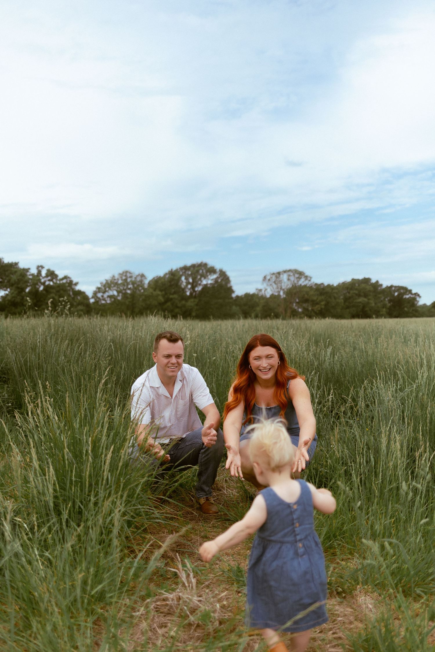 A joyful moment captured in a tall grass field on a sunny day.
