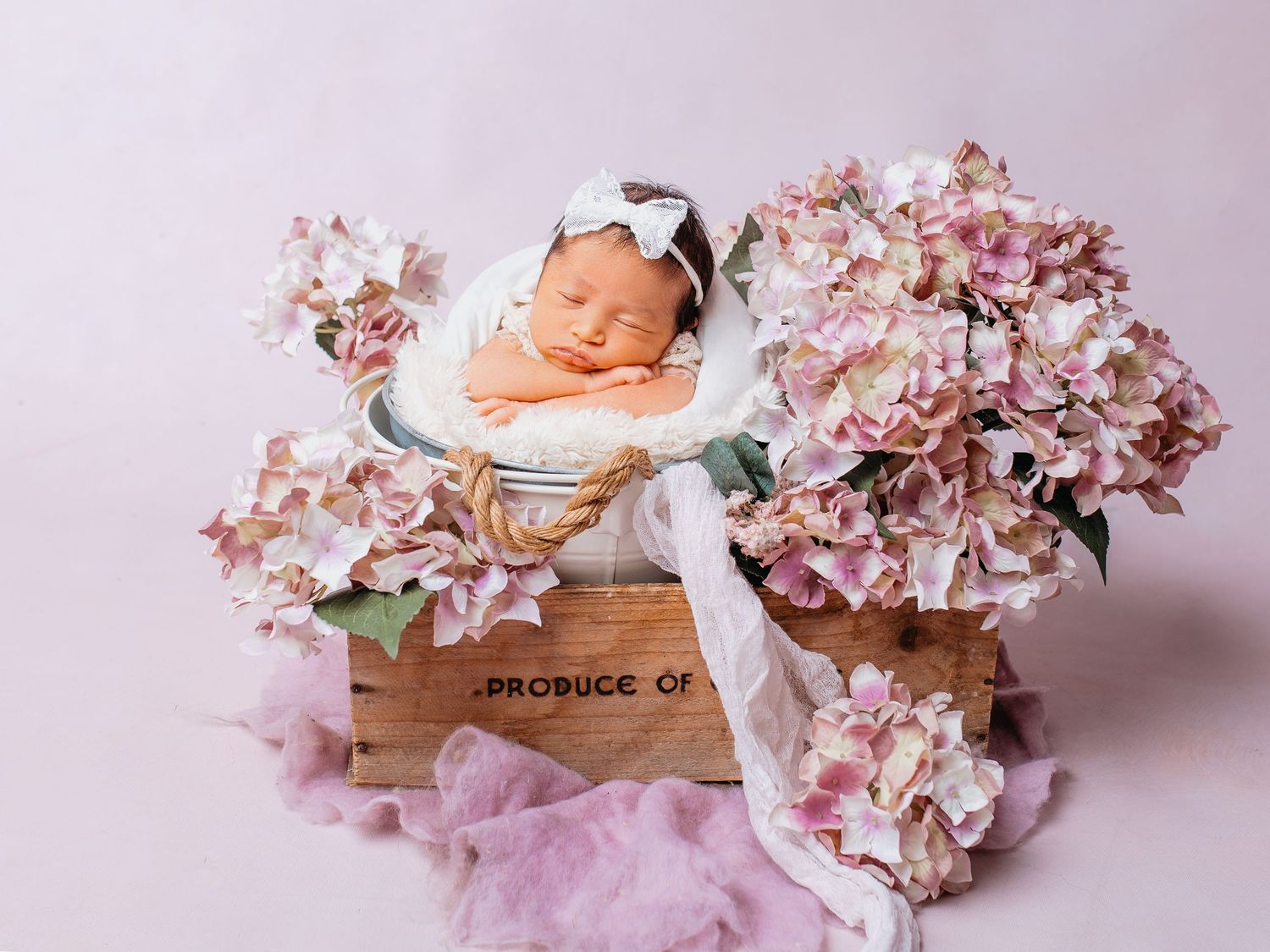 Baby in Topf mit Hortensien schlafend