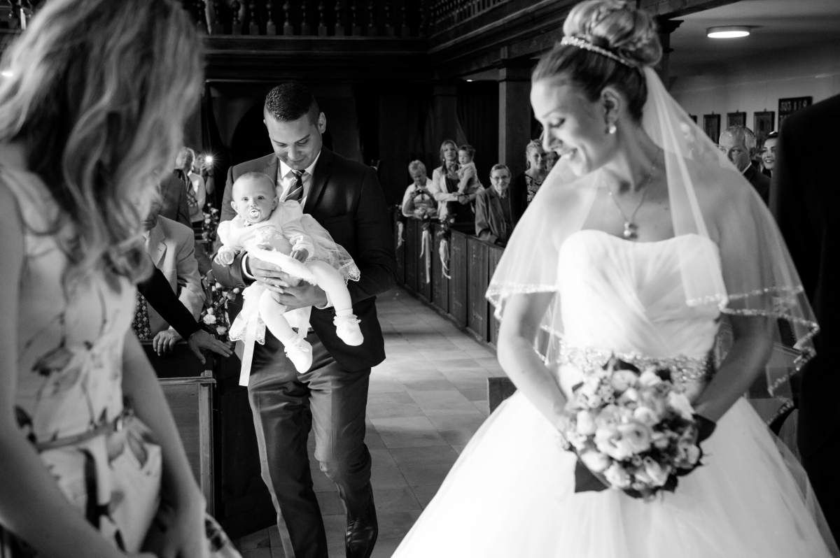 Braut schaut sich in Kirche zu ihrem Baby um