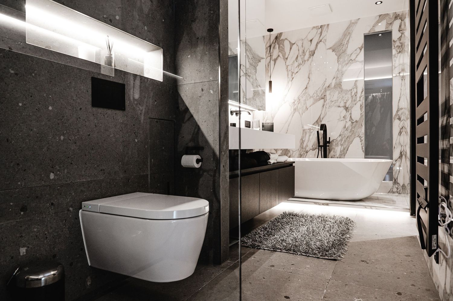 Badezimmer mit freistehender Badewanne und wc mit xxl Fließen
