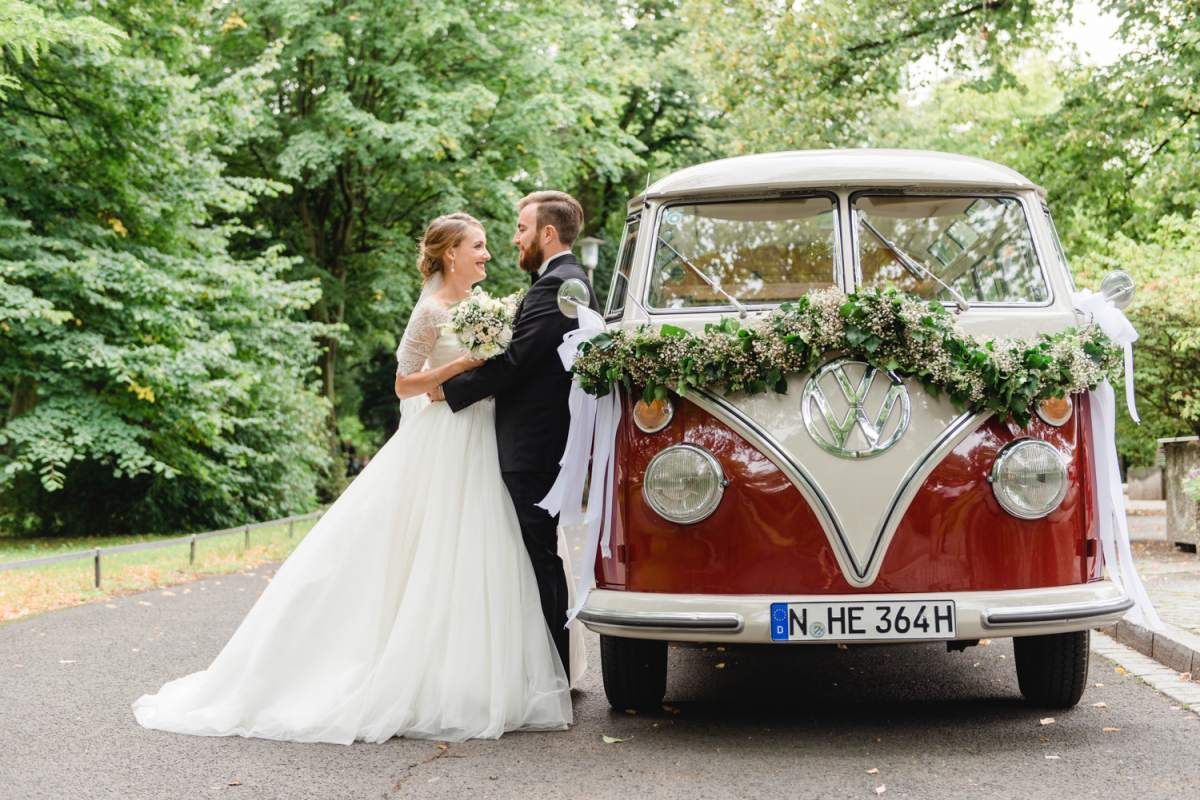 Brautpaar an einem alten VW Bulli mit Blumenschmuck
