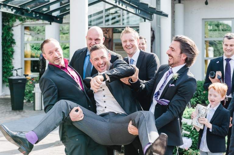 Bräutigam wird von seinen Freunden gehalten alle lachen