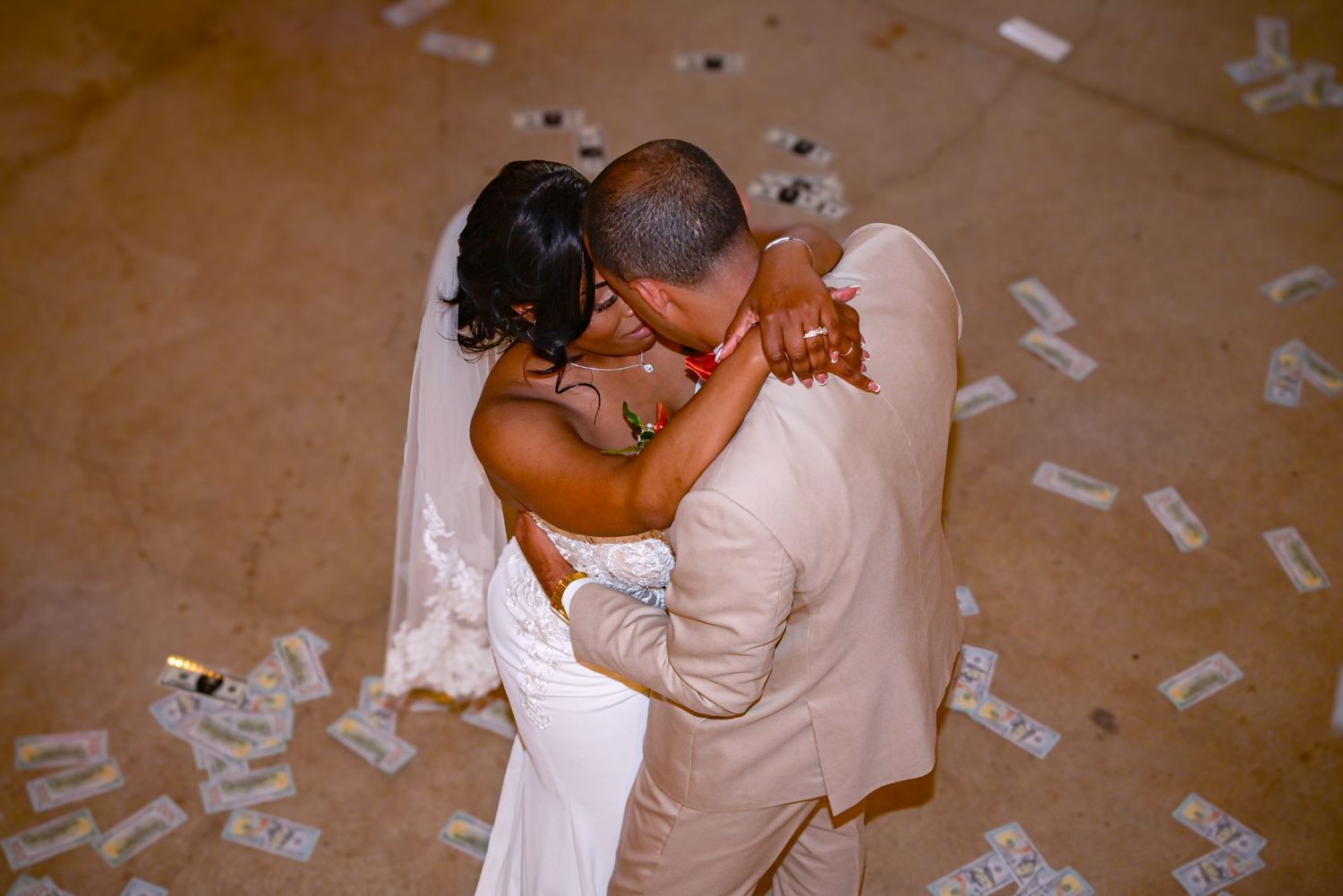 Couple in wedding attire share intimate moments during a celebration surrounded by confetti on the ground.