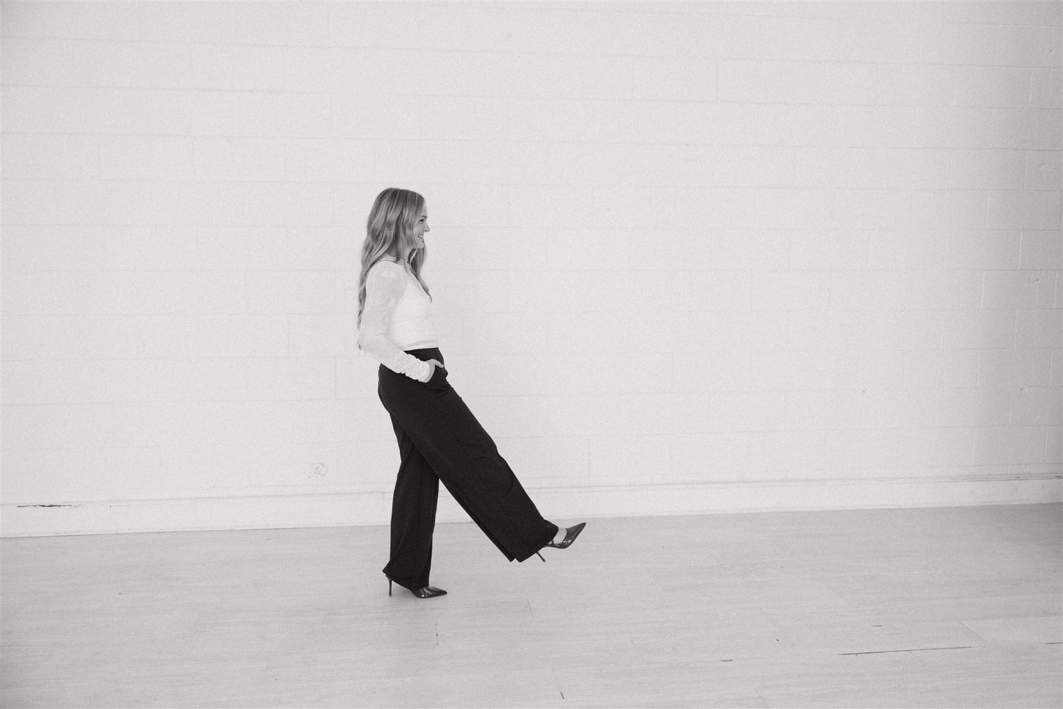 Black and white artistic photograph showing feet in motion against a white background.