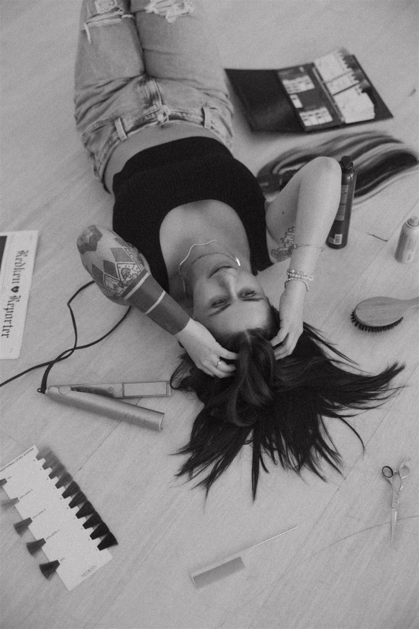 Artistic black and white overhead view of figures lying down with scattered items.