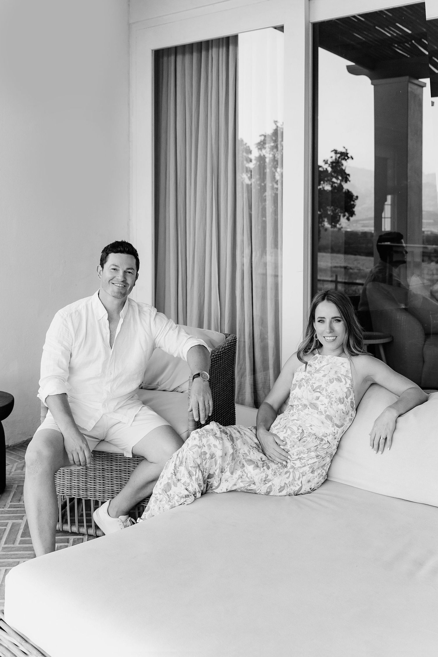 A black and white photo series showing a couple sitting together on a white sofa in a bright modern room.