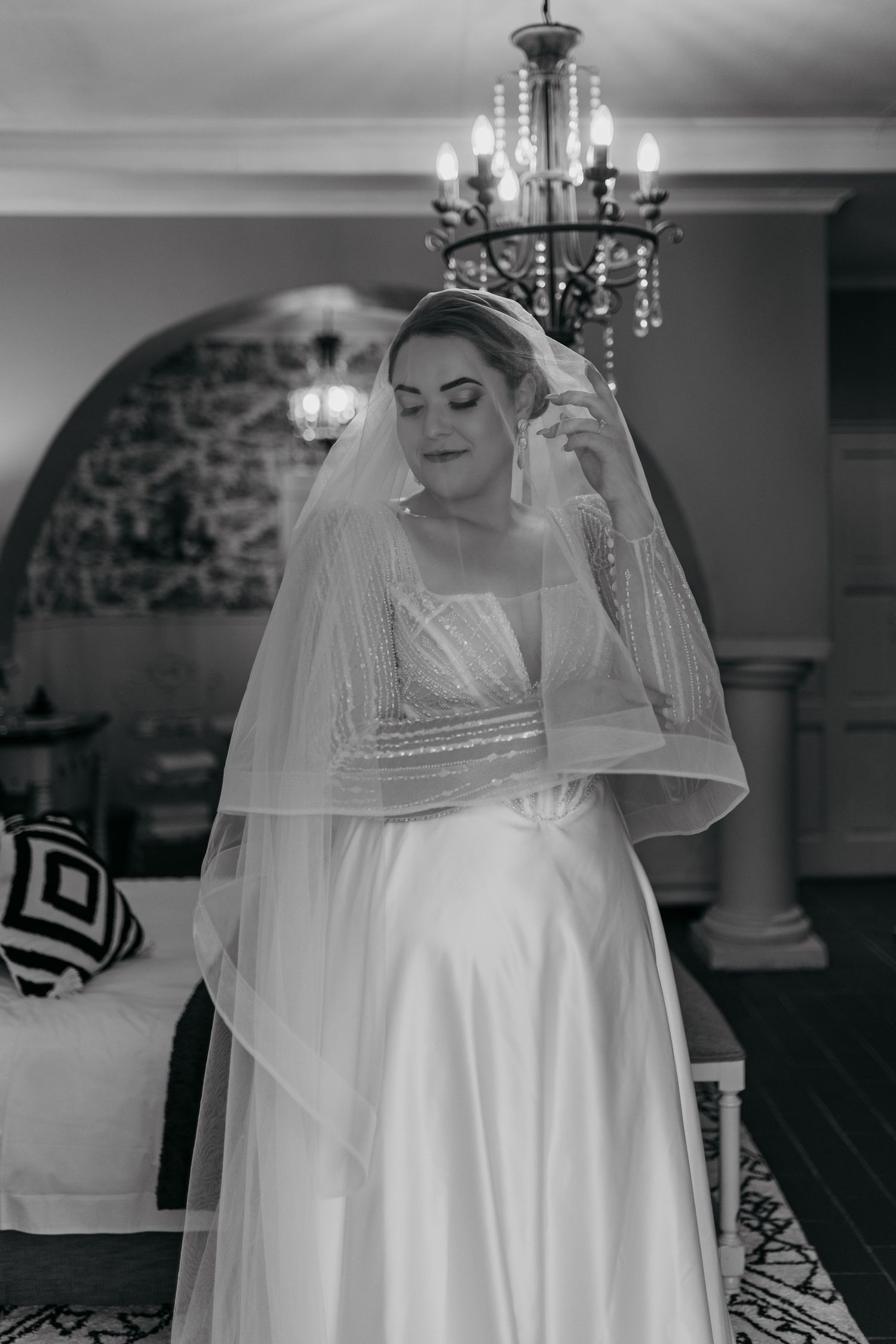 Black and white bridal portrait highlighting classic gown silhouette and delicate veil details.