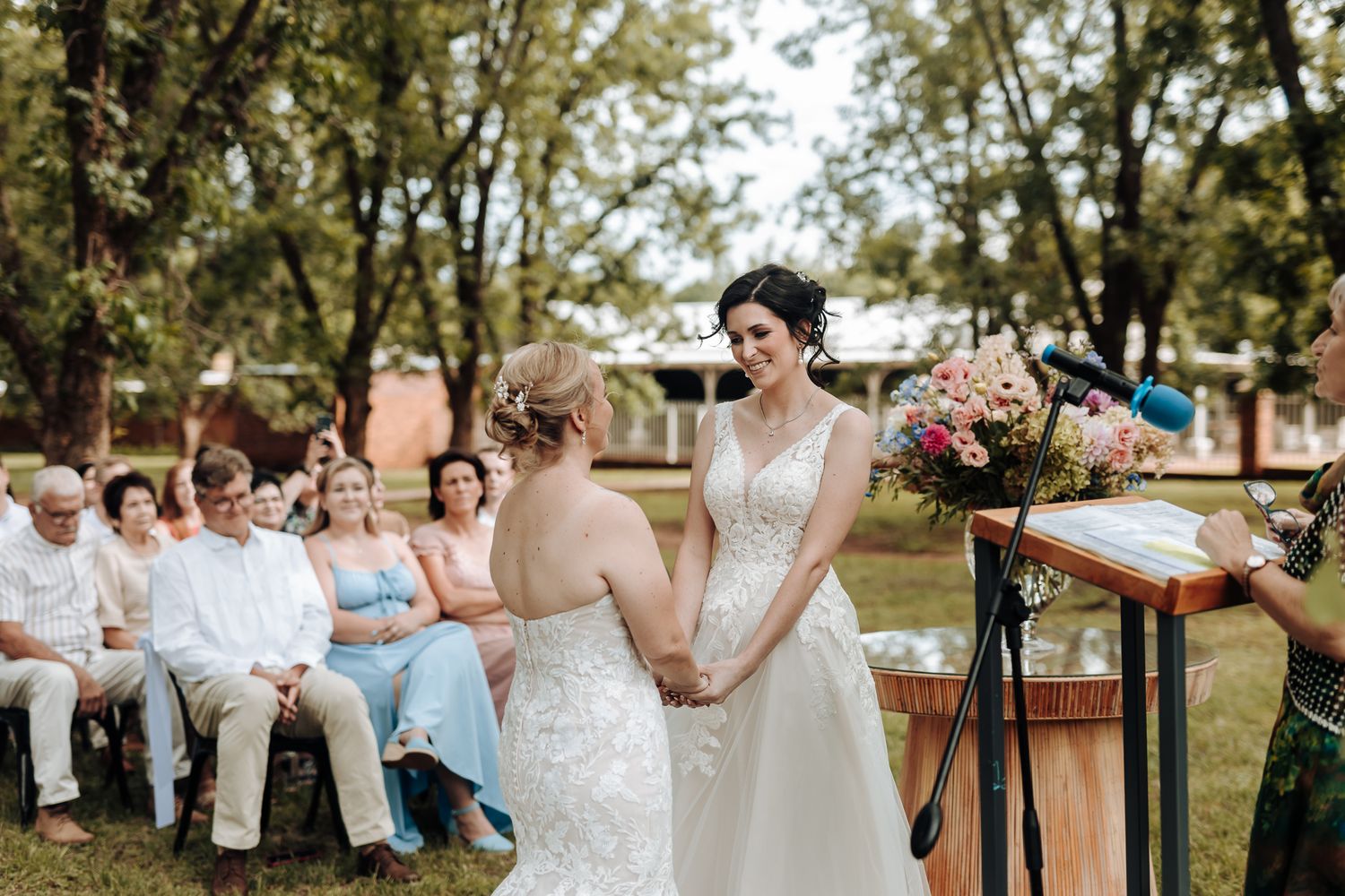 Outdoor wedding ceremony in a garden setting with colorful floral arrangements.