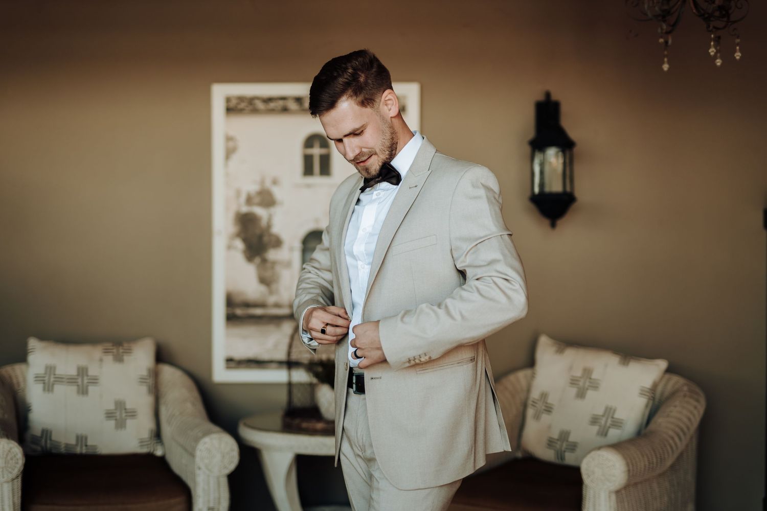 Elegant grey suit and bow tie combination photographed in vintage-styled interior.