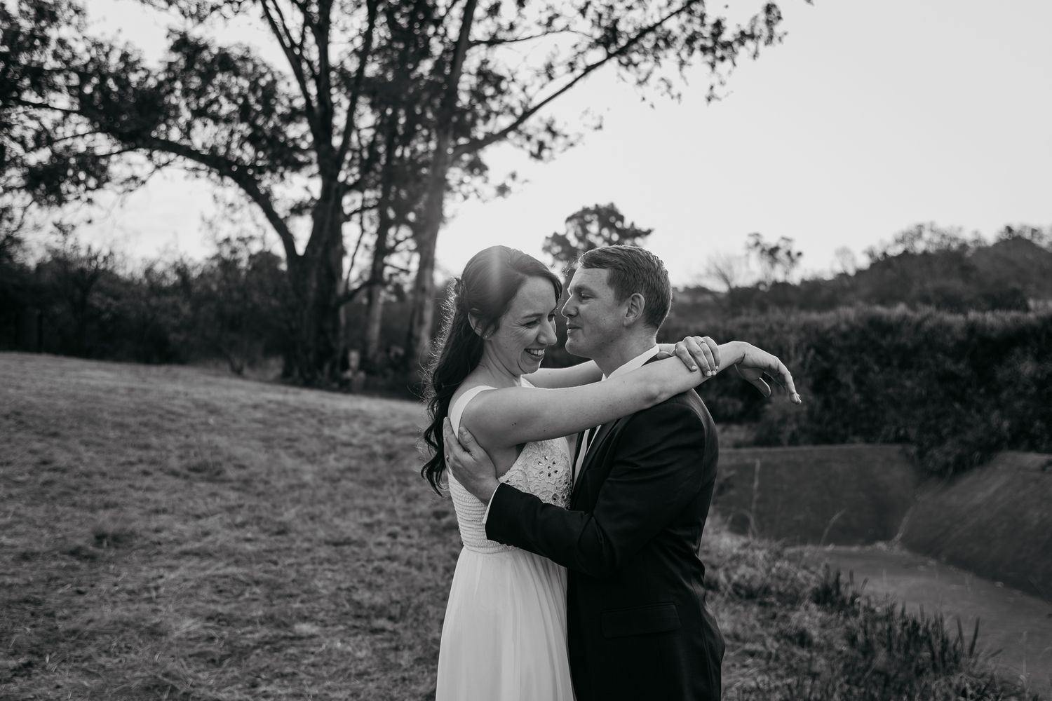 Black and white portrait session in a natural outdoor setting with trees.