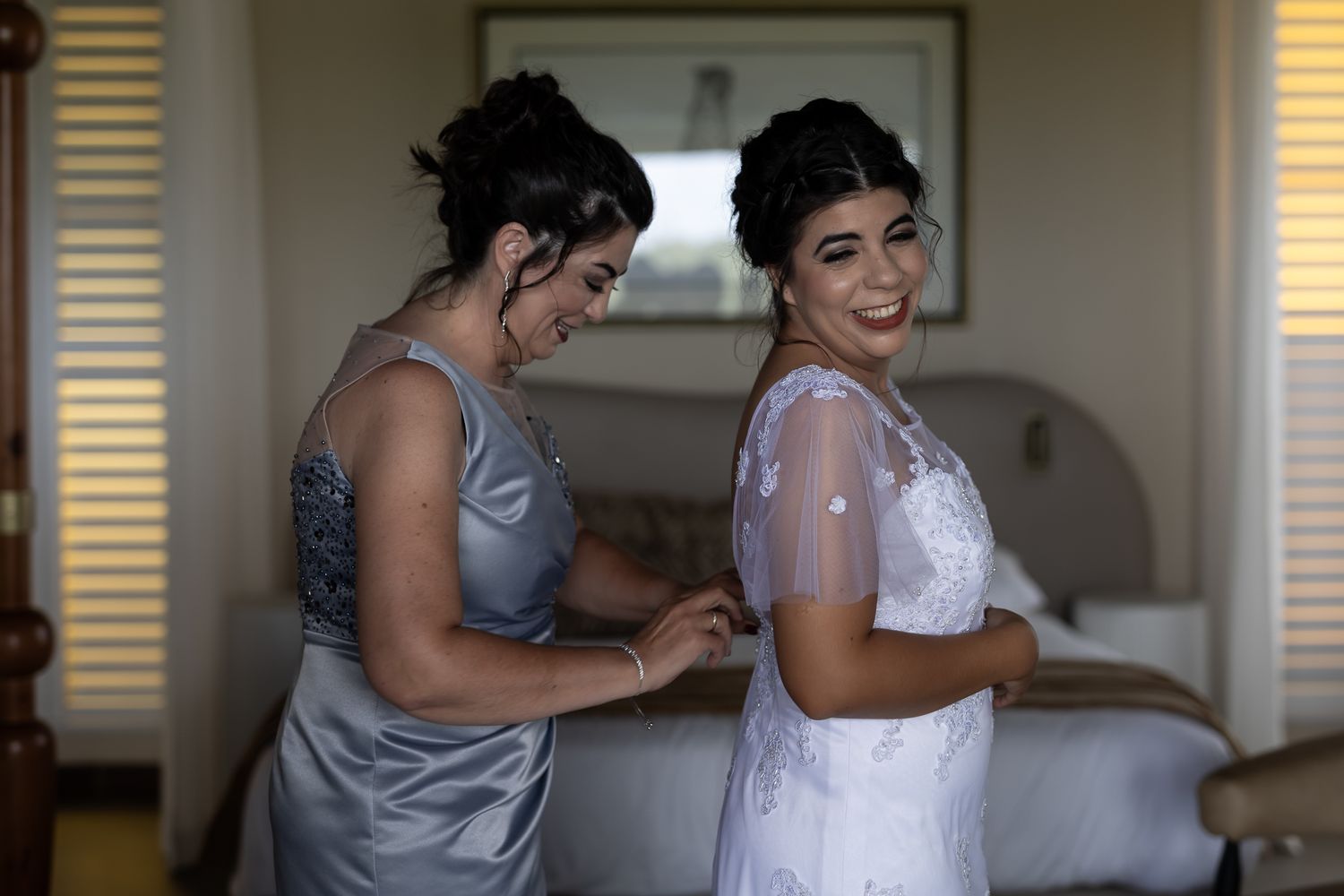 Getting ready scene with silver bridesmaid dress and white wedding gown.