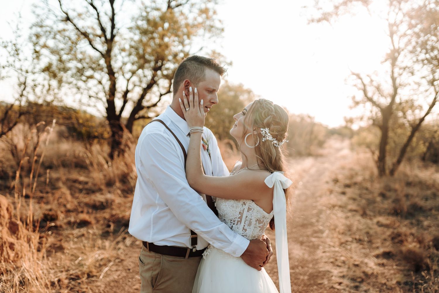 Romantic couple embracing on a dusty path surrounded by nature.