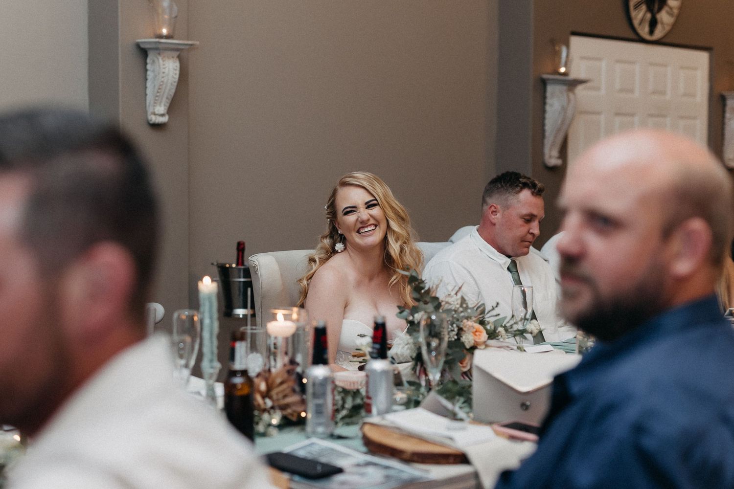 Wedding reception dinner setting with elegant table decor and ambient lighting.