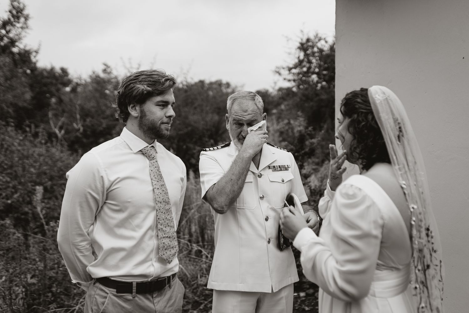 Black and white candid moment during outdoor wedding ceremony.