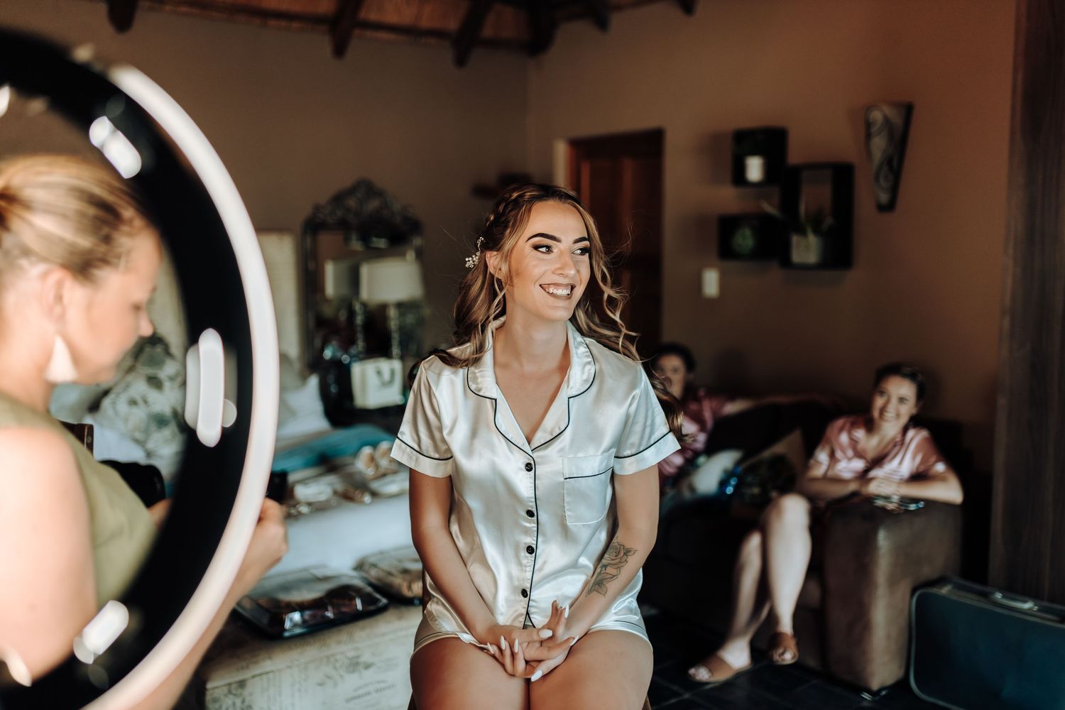 Behind-the-scenes getting ready shot showing preparations in a silk pajama set with ring light in the background.