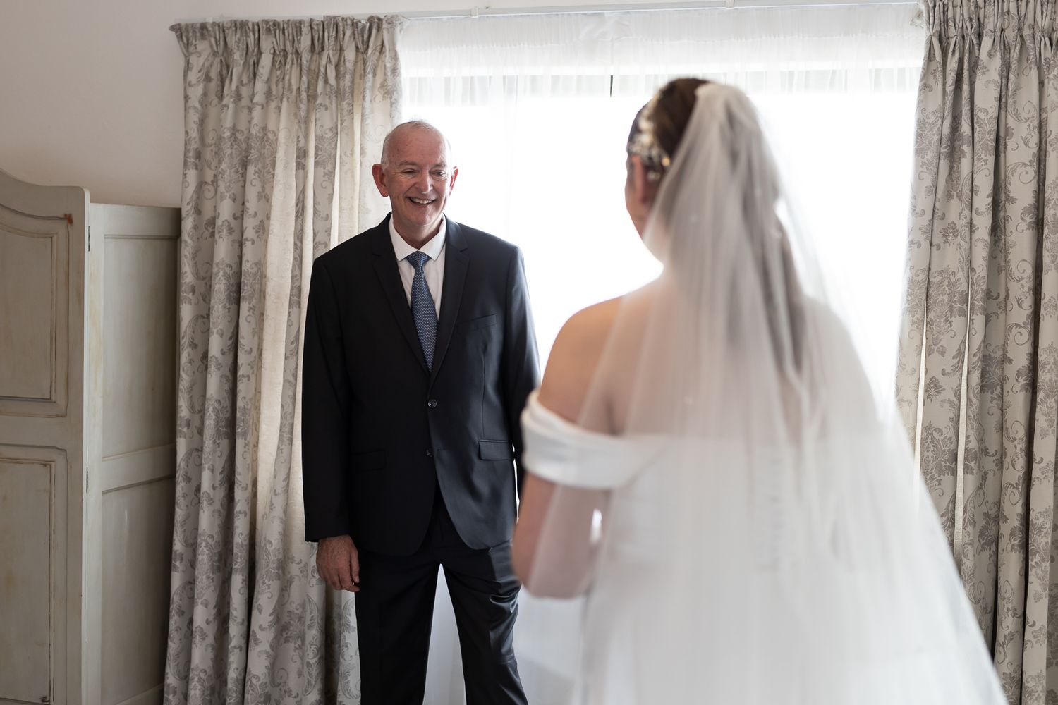 Emotional first look moment between two people in formal wedding attire.