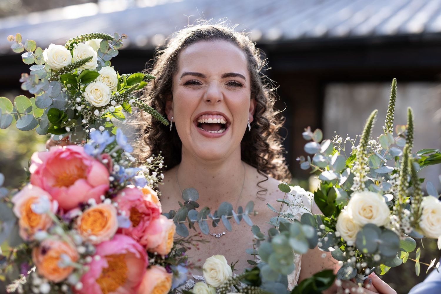 Joyful celebration with vibrant spring flowers and sunlit bouquets at an outdoor wedding ceremony.