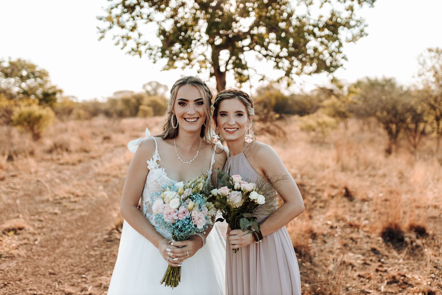 Wedding photo showing formal attire and bouquets against a golden sunset backdrop.