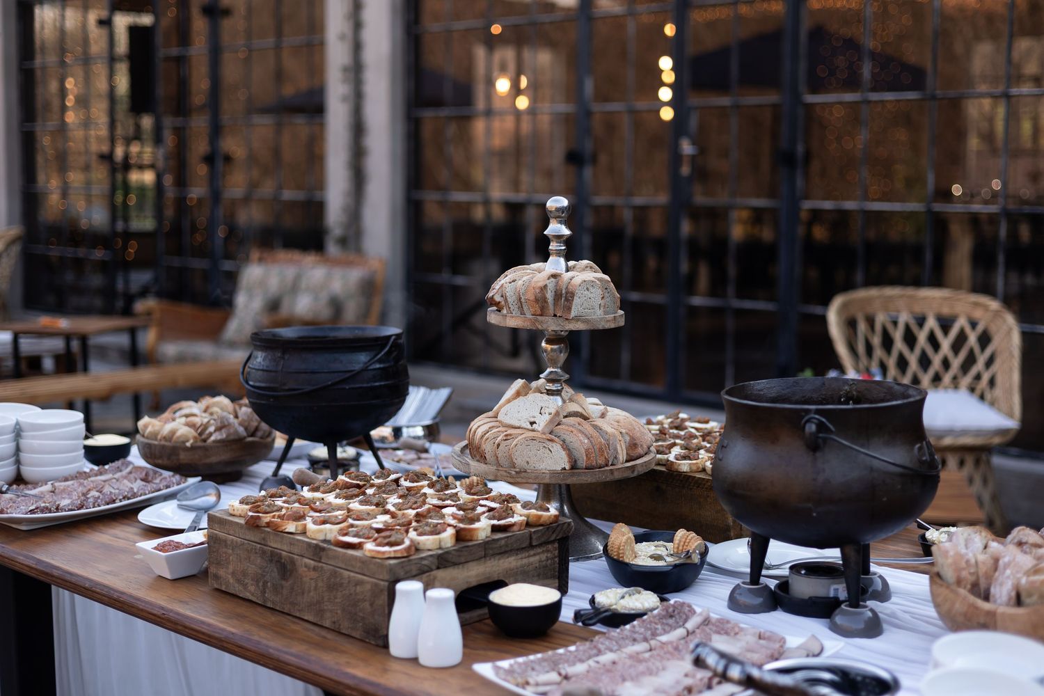 Rustic loaves of artisanal bread displayed on wooden boards in a cozy bakery setting with warm lighting.