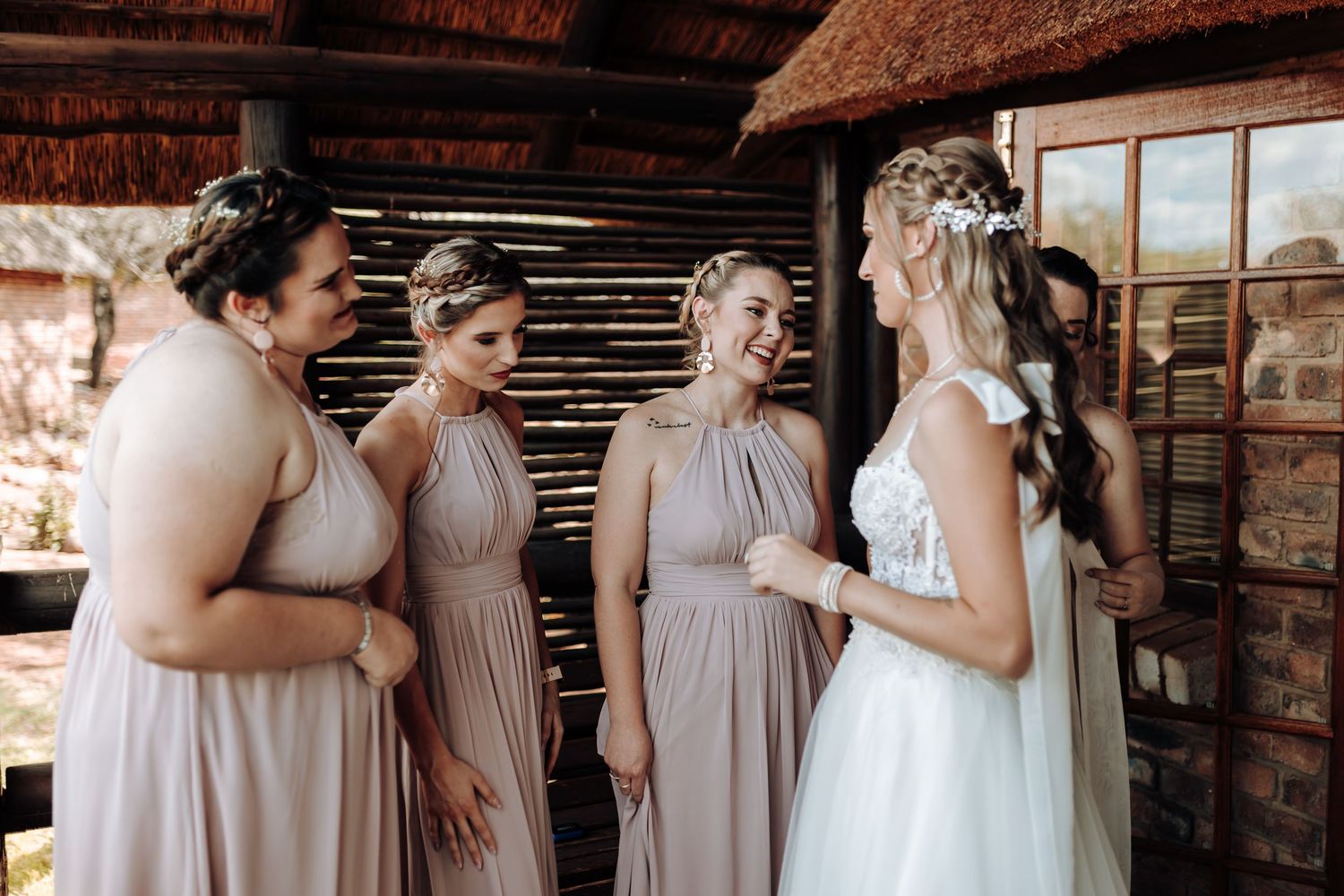 Wedding party shares an emotional moment during a first look in a rustic venue.